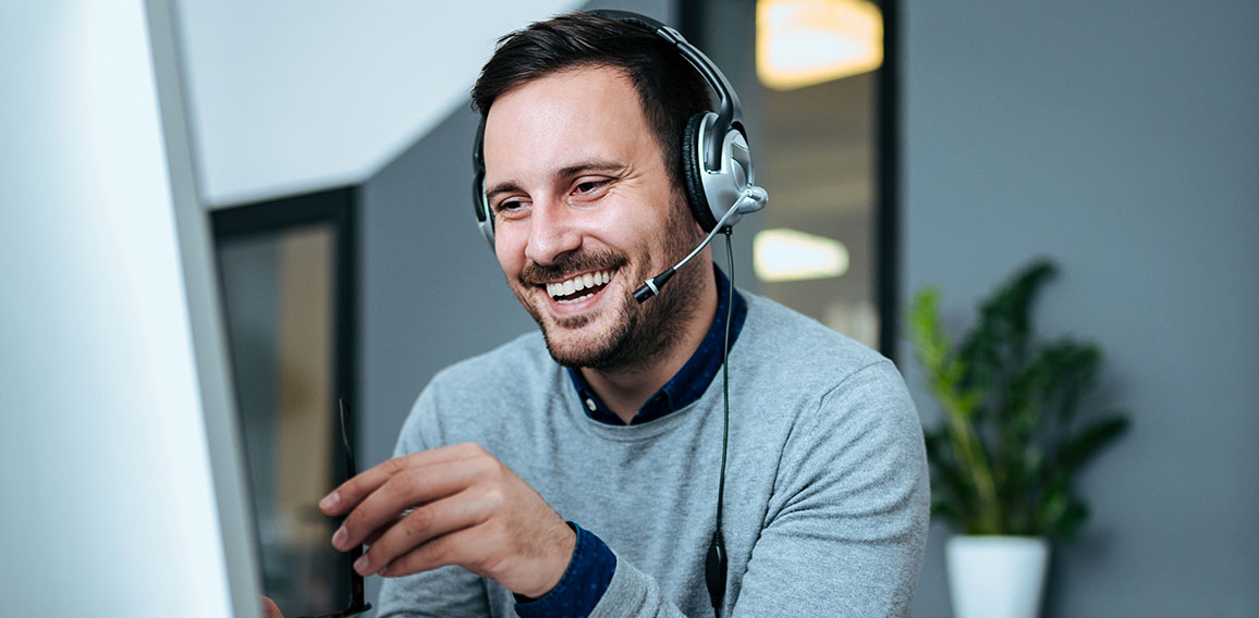 Casual smiling businessman with headset at work in modern office