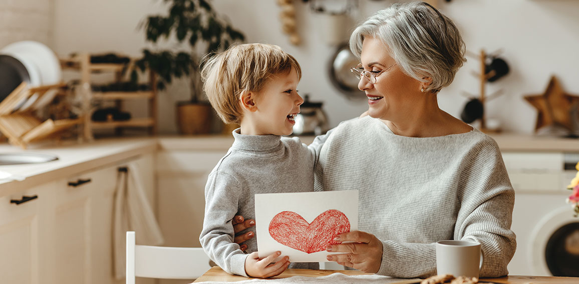 happy family grandson child congratulates grandmother on holiday and gives card