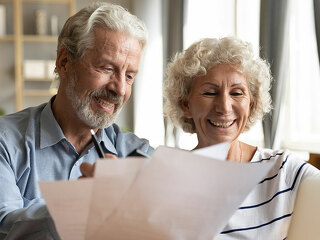 Senior couple use online banking on laptop planning family budget