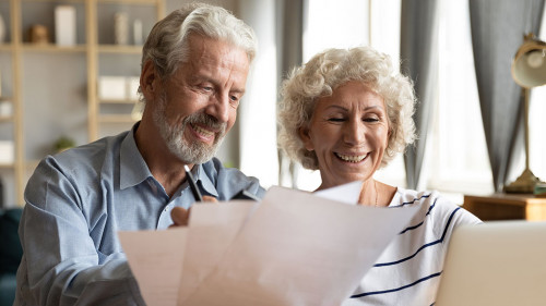 Senior couple use online banking on laptop planning family budget