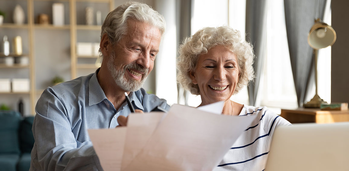 Senior couple use online banking on laptop planning family budget