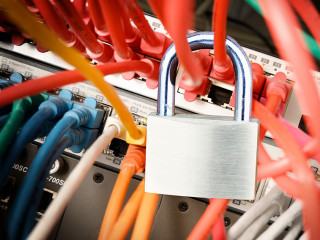 padlock on the colorful cables at a network server, safety conce