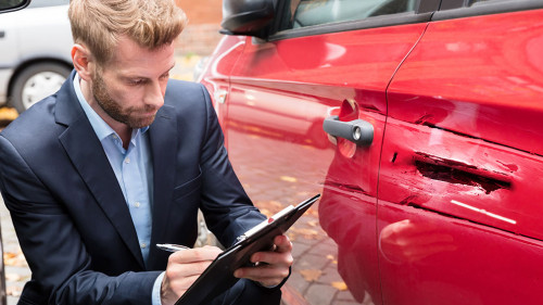 Insurance Agent Examining Car After Accident