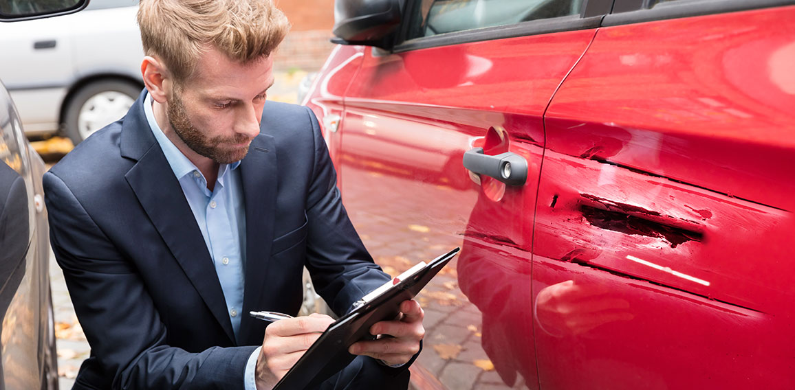 Insurance Agent Examining Car After Accident
