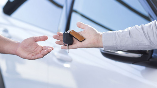 Panorama and close-up of car seller's hand with keys and buyer's