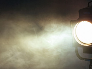 theater spot light with smoke against grunge wall