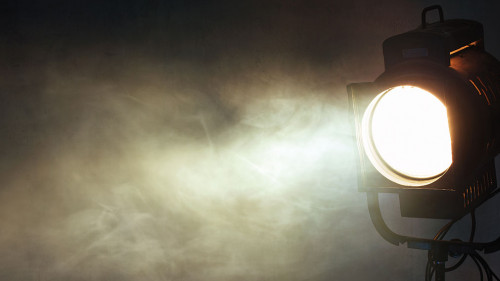 theater spot light with smoke against grunge wall