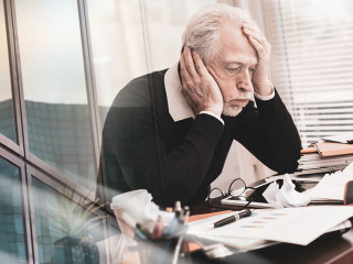 Overworked businessman sitting at a messy desk; multiple exposur