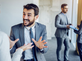 Cheerful caucasian businessman sitting on table in building in c