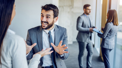Cheerful caucasian businessman sitting on table in building in c