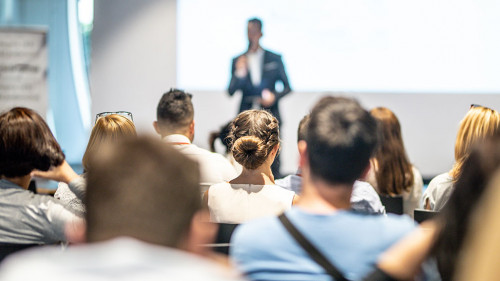 Male business speaker giving a talk at business conference event.