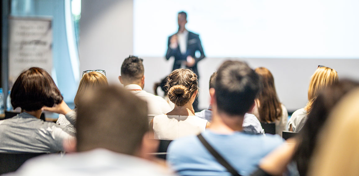 Male business speaker giving a talk at business conference event.