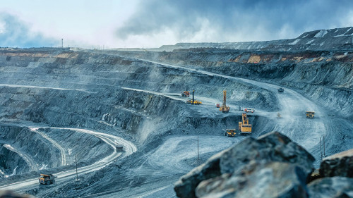 Work of trucks and the excavator in an open pit