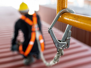 Construction worker wearing safety harness and safety line worki