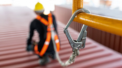 Construction worker wearing safety harness and safety line worki