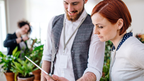 Two young businesspeople using tablet in office, start-up concept.