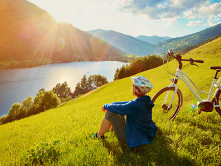 woman resting above a lake with her e-bike/e-power 14