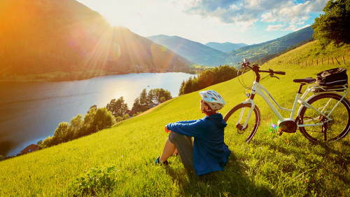 woman resting above a lake with her e-bike/e-power 14