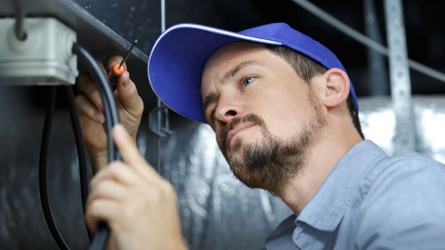 an electrician is fixing an electric cable