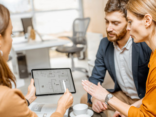 Young couple choosing house at the real estate agency