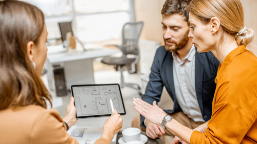 Young couple choosing house at the real estate agency