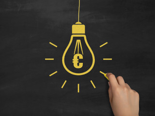 Euro Symbol Bulb Drawing with Chalk on Blackboard by Female Hand