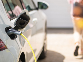 Close up of a electric car charger with female silhouette in the