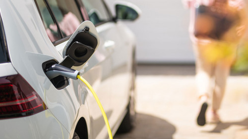 Close up of a electric car charger with female silhouette in the