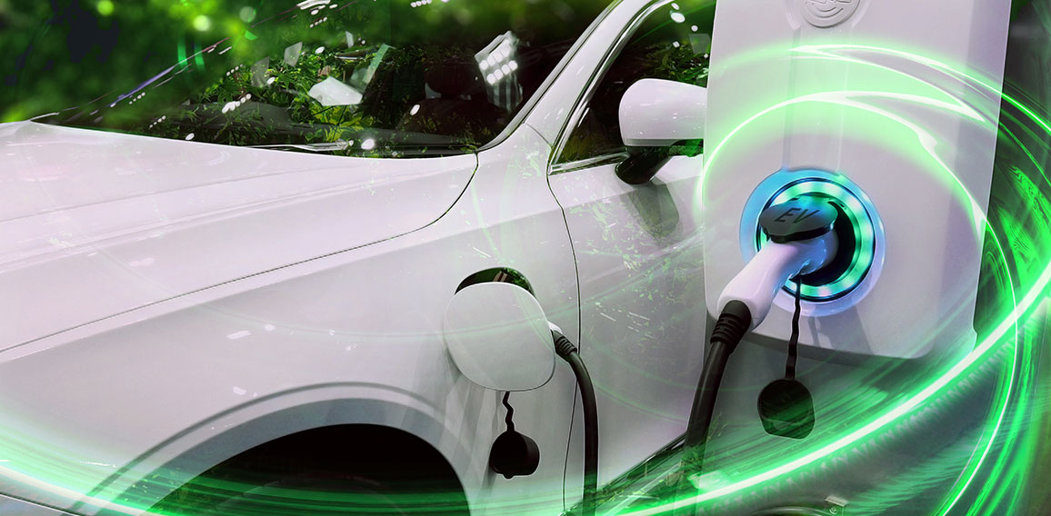 EV Car or Electric vehicle at charging station with the power cable supply plugged in on blurred nature with green energy power effect. Eco-friendly sustainable energy concept.