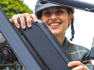 woman holding an electric bike battery mounted on frame