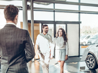 young family comes into Car dealership to choose the car to buy