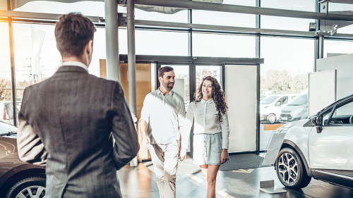 young family comes into Car dealership to choose the car to buy