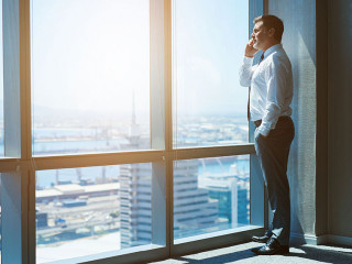 Mature business executive in top floor office space on phone