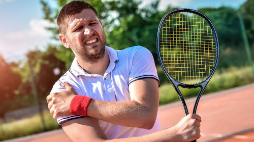 Shot of a tennis player with a shoulder injury on a clay court