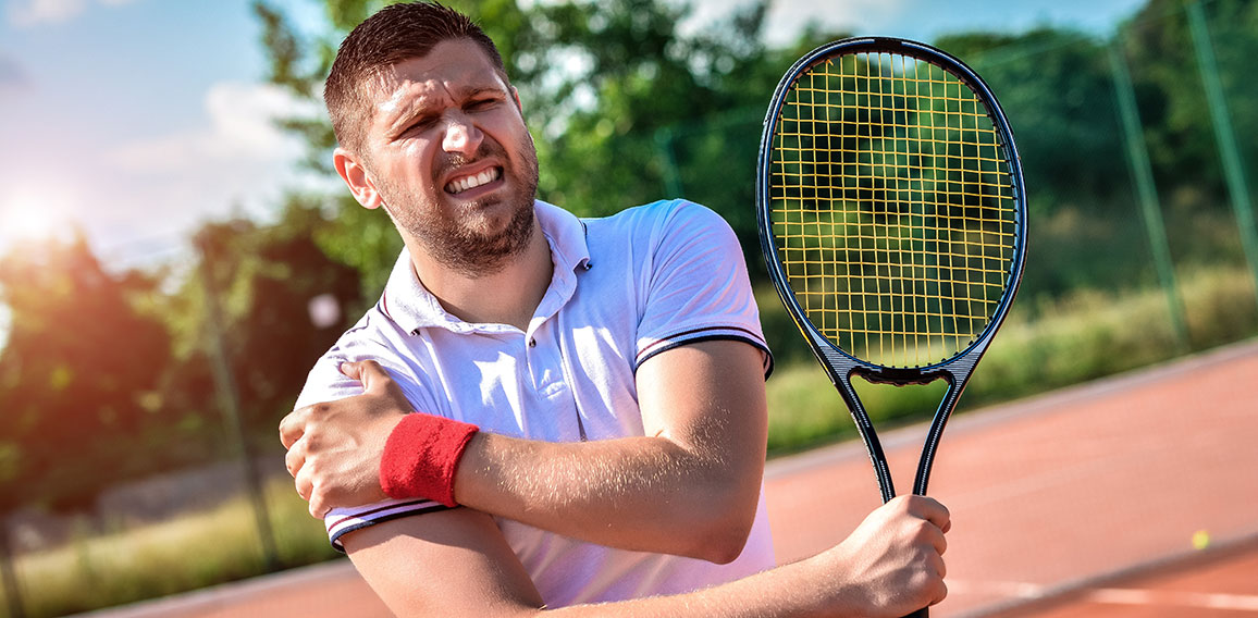 Shot of a tennis player with a shoulder injury on a clay court