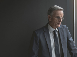 Thoughtful old businessman watching at street