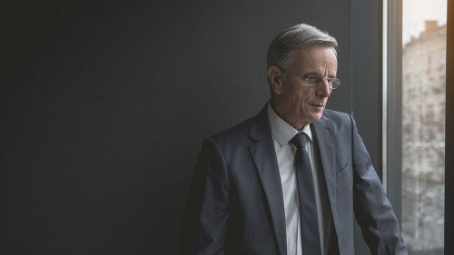 Thoughtful old businessman watching at street