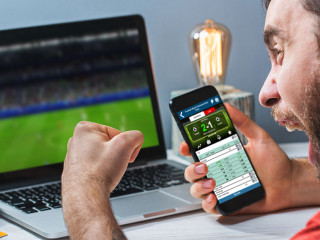 Guy being happy winning a bet in online sport gambling application on his mobile phone