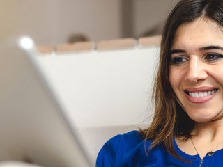 Young caucasian happy woman sitting on the sofa doing online sho
