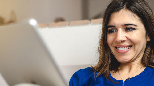 Young caucasian happy woman sitting on the sofa doing online sho