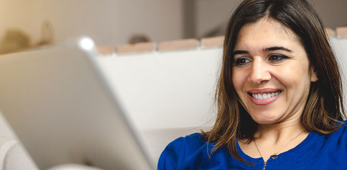 Young caucasian happy woman sitting on the sofa doing online sho