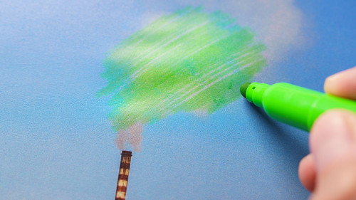 Man painting green pollution from a chimney