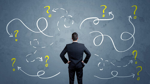 Unsure businessman with question marks