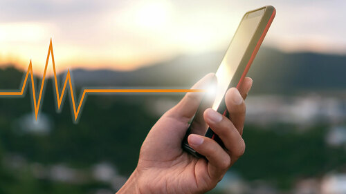 Woman hand holding smartphone with vital sign of heart beat back