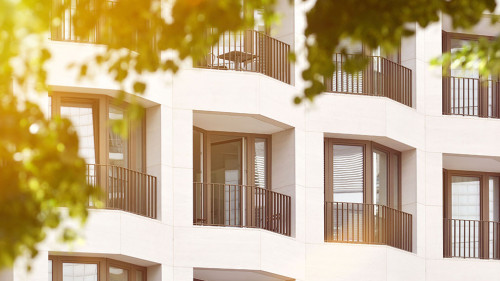The facade of a high building with some windows closed by blinds