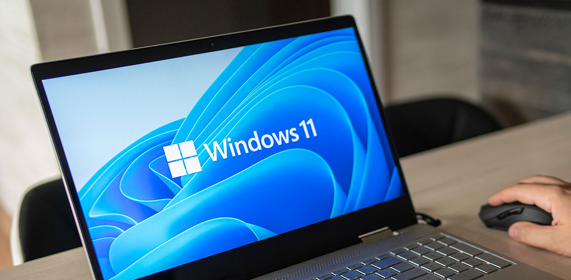 Windows 11 logo on laptop screen. A new operating system update from Microsoft