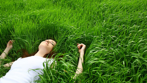 beautiful girl lying down of grass