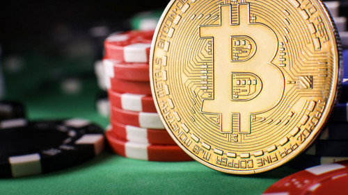 Bitcoin gold coin with poker chips on a green poker table agains