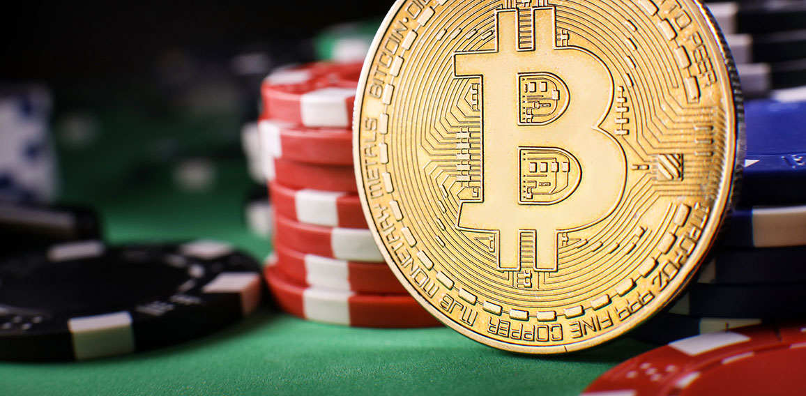 Bitcoin gold coin with poker chips on a green poker table agains