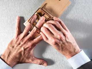 businessman removing his hand a mouse trap with bank note